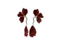 Caravanas largas con diseño floral escultural en color rojo brillante, con tallo plateado texturizado y pétalo colgante asimétrico.
