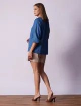 Blusa celeste de tencel con cuello redondo, escote en V y lazo de ajuste. Tiene cuello y escote calado y mangas 3/4 amplias con puño elastizado.