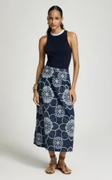 Musculosa azul marino de punto acanalado, con escote redondo ribeteado en celeste y blanco, de corte ajustado y sisas amplias.