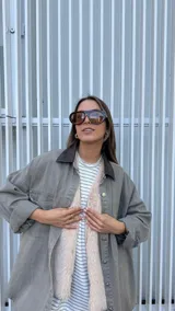 Sobrecamisa de denim en color gris con lavado desgastado, corte oversize y cuello de cuero sintético en color marrón chocolate. Cuenta con cierre frontal de botones metálicos.