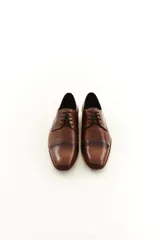 Zapato de vestir acordonado de cuero vacuno marrón, con puntera distinguida y suela con sutil tacón.