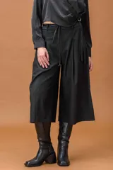 Bermuda de tiro alto con diseño amplio y tablas delanteras, confeccionada en tela sastrera con sutil estampado de rayas verticales. Incluye cinturón fino de cuero.
