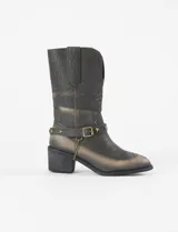 Botas estilo tejano de cuero vegano en tono marrón con efecto desgastado. Presentan costuras decorativas, una correa ajustable con tachas en forma de estrellas y una pequeña cadena colgante en el lateral.