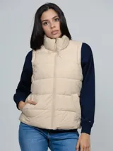 Chaleco acolchado de cuello alto con cierre frontal de cremallera y dos bolsillos laterales de ojal. Presenta un diseño moderno y ligero, con detalles distintivos de la marca.