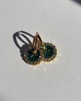 Aros de acero quirúrgico con dije circular de resina rosa y borde de strass dorados.