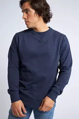 Buzo clásico de cuello redondo y manga larga, en color gris melange. Presenta un ajuste regular y un logo bordado con detalle en goma en el pecho.