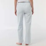 Pantalón de pijama de corte recto y holgado, confeccionado en tela de popelina con estampado de rayas verticales finas en tonos azul y blanco. Cuenta con cintura elástica para mayor comodidad.