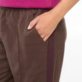 Pantalón marrón con diseño a cuadros, corte palazzo, cintura alta con pinzas, bolsillos laterales y bandas laterales en color borgoña.