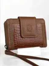 Mini billetera de cuero color marrón con textura combinada, lisa y efecto croco en la solapa. Cuenta con cierre perimetral, múltiples ranuras para tarjetas y una correa de muñeca extraíble.