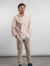 Camisa de corte regular confeccionada en algodón, con diseño de rayas verticales en tonos azul y blanco. Presenta cuello con botones, cierre frontal abotonado, bolsillo en el pecho con logo bordado y mangas largas.