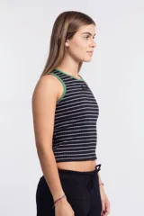 Musculosa corta a rayas horizontales negras y blancas, con cuello y sisas ribeteadas en verde. Presenta un logo ovalado en el pecho.