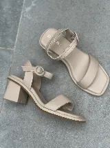 Sandalias de cuero color beige con taco cuadrado y tira delantera acolchada.
