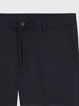 Pantalón de vestir azul oscuro, corte moderno, con pliegues marcados en el frente y cierre de botón.