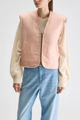 Chaleco reversible de calce relajado color rosado con escote en V y diseño acolchado. Cuenta con bolsillos laterales y cierre frontal de cremallera.