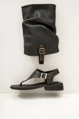 Sandalias negras de cuero ultra suave con diseño de caña alta fruncida y calce tipo ojota con suela plana.