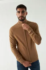 Campera tejida color marrón claro, con cuello alto, cierre frontal completo y mangas largas.