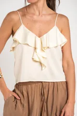Musculosa de satén color marfil, con escote en V y volados frontales. Presenta tirantes finos.