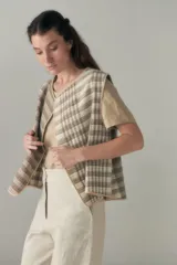 Chaleco color beige con textura tipo espiga, corte holgado y solapa cruzada.