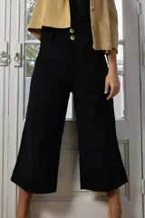 Pantalón negro de pana de algodón elastizada, corte cropped y pierna ancha.