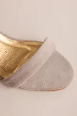 Sandalias de taco cuadrado y altura media, con tira delantera simple y tira ajustable al tobillo mediante hebilla metálica.
