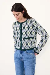 Saco de punto con diseño de rombos en tonos verde, amarillo y gris. Presenta cuello redondo, cierre frontal con botones y dos bolsillos delanteros con terminaciones en contraste.