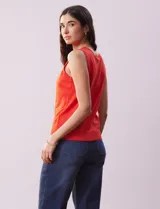 Musculosa tejida color naranja, de hilado fino y cuello redondo.