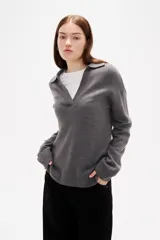 Sweater de punto color azul, con cuello polo y escote en V, de manga larga y diseño holgado.