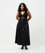 Falda midi de corte evasé confeccionada en cuero sintético (PU) de color negro. Presenta cintura estructurada con pasacintos y diseño de paneles verticales que aportan fluidez a la prenda.