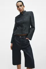 Bermuda de tiro medio confeccionada en denim de algodón, con diseño de cinco bolsillos, trabillas en la cintura y costuras a contraste.