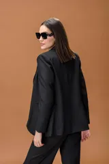 Blazer de corte clásico y estructurado en color marrón con textura de espiga. Presenta solapas tradicionales, cierre frontal y mangas largas.