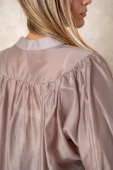 Camisa de organza blanca con cuello mao, diseño de manga larga tipo murciélago y cierre frontal con botones. Presenta un corte holgado y fluido.
