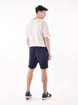 Bermuda negra con textura acanalada horizontal, corte a la rodilla y cintura con cordón ajustable.