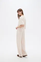 Pantalón ancho de tiro alto, color natural, confeccionado en poliéster con detalles de strass.
