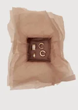 Set de aros dorados compuesto por cuatro piezas: un aro tipo argolla con incrustaciones de cristales, un aro pequeño con un cristal central, un ear cuff texturizado y un ear cuff liso.