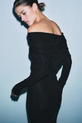 Vestido largo negro de manga larga confeccionado en mezcla de viscosa. Presenta cuello amplio multiposición y detalle de drapeado fruncido en el lateral del torso.