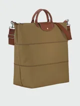 Bolso de viaje ampliable Longchamp de la línea Le Pliage Original, color marrón caqui con detalles en cuero marrón y herrajes metálicos plateados. Cuenta con asas de mano y correa de hombro ajustable y extraíble.