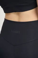 Calza larga negra de tiro alto, confeccionada en tejido de poliamida y elastano.