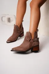 Botines texanos de cuero color marrón con diseño de piel de serpiente, corte en V en los laterales, apliques de tachas metálicas y hebilla decorativa. Taco de madera.