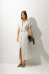 Vestido camisero midi a rayas verticales color blanco y beige, con cuello camisero, mangas cortas con dobladillo, cierre frontal con botones y cinturón con hebilla forrada.