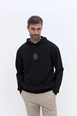 Canguro negro con capucha y cordones ajustables. Presenta un estampado pequeño en el pecho con la frase 'Find Your Focus' y un bolsillo frontal tipo canguro.