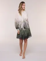Vestido corto de gasa estampada con motivos botánicos en tonos verdes y crudo, diseñado por Julia Jordan. Cuenta con cuello alto con lazo para atar, abertura frontal con botones, delantera plisada, mangas largas abullonadas y un lazo ajustable en la cintura. Incluye forro interno.