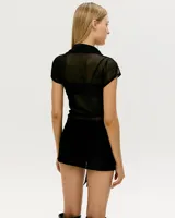 Body negro de mangas cortas, con cuello tipo camisa y botones frontales.