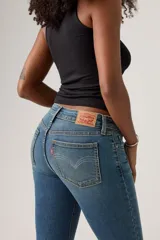 Jeans de mujer de tiro bajo, color azul medio con efecto lavado, corte bootcut y cierre de botón y cremallera.