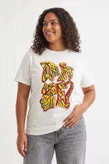 Remera blanca de manga corta y cuello redondo, con estampado frontal estilo animal print y detalles gráficos.
