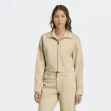 Campera Adidas Firebird color beige, con cierre frontal y cuello alto. Presenta las tres tiras características de la marca en las mangas y logo bordado en el pecho. Corte por encima de la cintura.