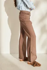 Pantalón morado de corte acampanado con volados decorativos en la cintura y en el ruedo.