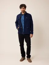 Camisa de manga larga en color azul, confeccionada en algodón con técnica de teñido garment dye. Presenta cuello abotonado, cierre frontal con botones y un bolsillo en el pecho con detalle bordado.