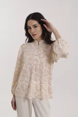 Blusa estampada con motivos cachemira en tonos crudo y rojo, con cuello mao y cierre frontal con botones.