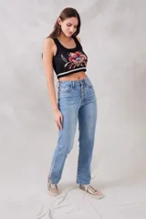 Musculosa corta de punto negra con diseño floral bordado en el frente y rayas horizontales blancas en el ruedo.