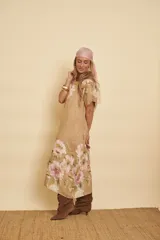 Vestido midi de lino color tostado con mangas cortas y estampado floral en tonos rosados y verdes. Presenta un diseño holgado y fresco.